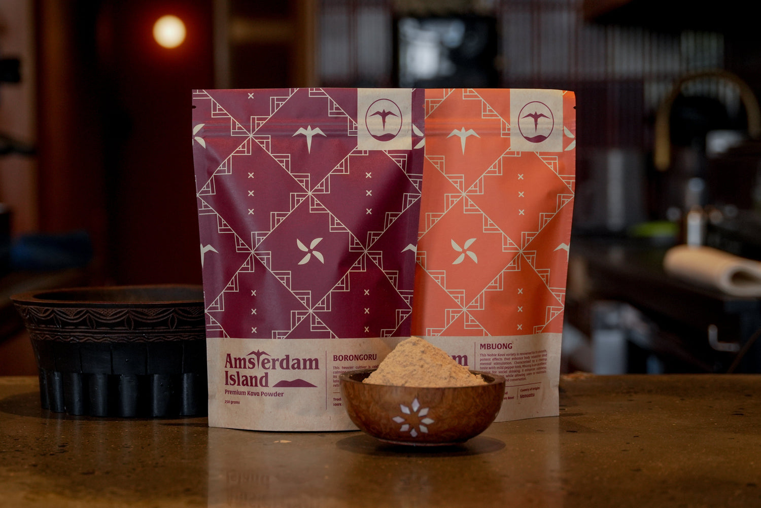 Two Amsterdam Island Kava packages with 'Amsterdam Island' branding on a wooden surface.